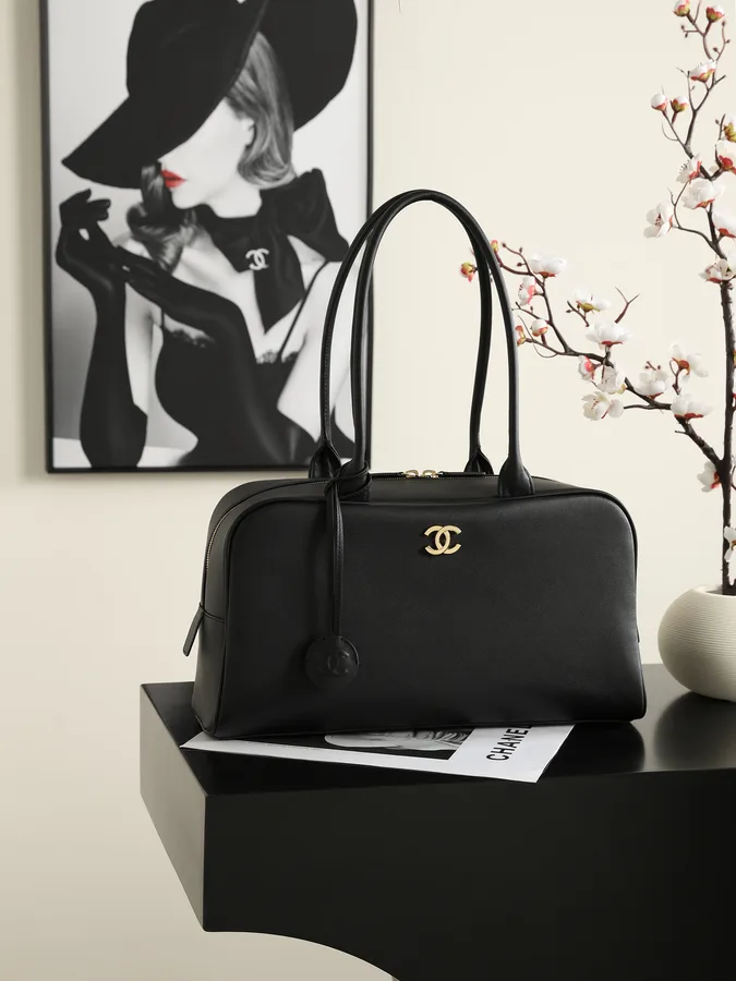 Mini bolso Chanel en piel negra lisa con asa corta y detalle metálico