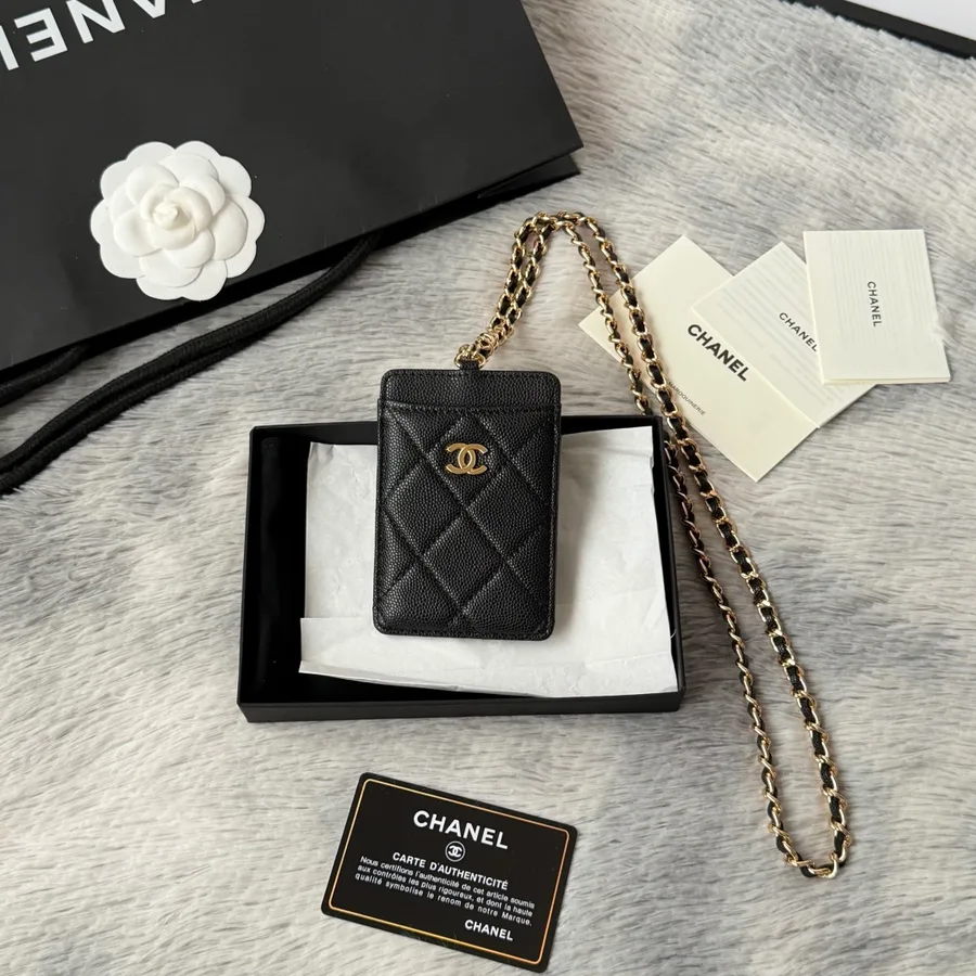 Chanel Kartenetui aus schwarzem, genarbtem Leder mit goldfarbenen Beschlägen auf hellem Grund
