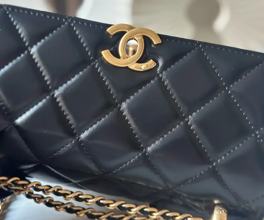 Black quilted flap in smooth leather with an aged-gold CC and a leather-woven chain, the soft, slightly glossy surface typical of lambskin