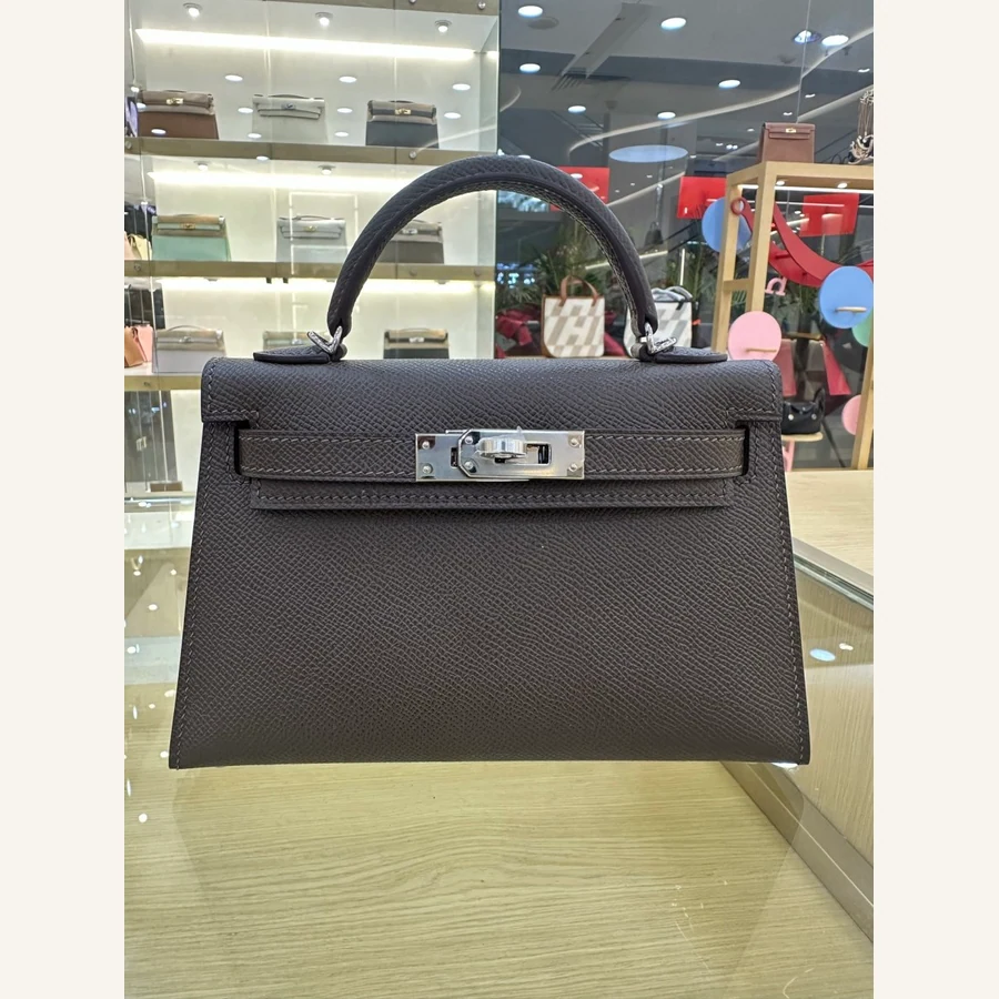 Hermès Birkin-style two-handle tote: rolled top handles, twin sangles over the front plaque and four base feet, front view — catalog reference