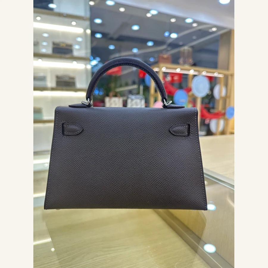Brown grained leather top-handle bag with a front flap, two side tabs and silver-tone hardware, from the GunongTrade catalog
