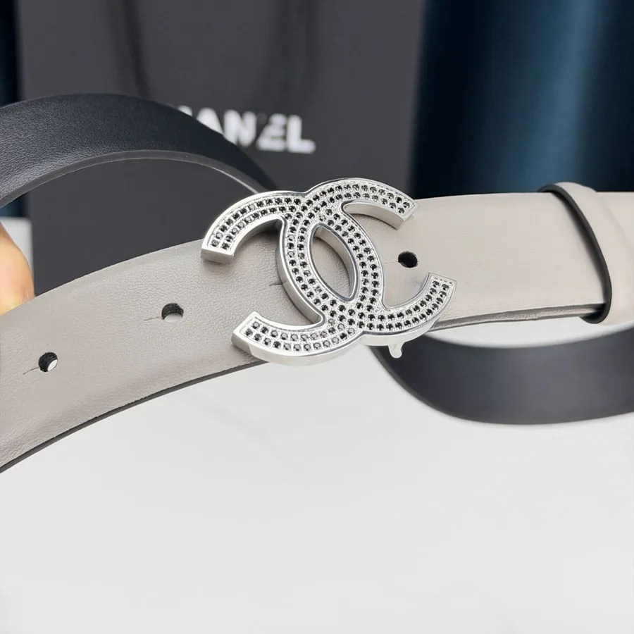Grey leather Chanel belt with a silver-tone interlocking CC buckle set with small black stones, the reverse face in black leather