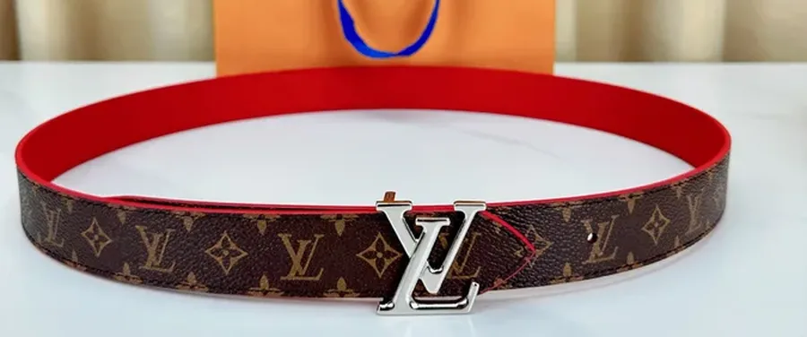 Louis Vuitton 30 mm reversible belt in Monogram canvas with a silver-tone LV Initiales buckle, the red reverse face showing on the inside of the loop