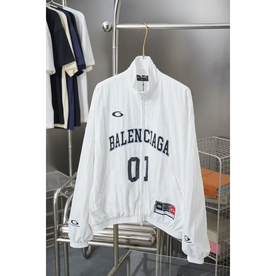 White zip-up jacket with a stand collar, gold-tone zipper and a printed logo and 01 on the chest