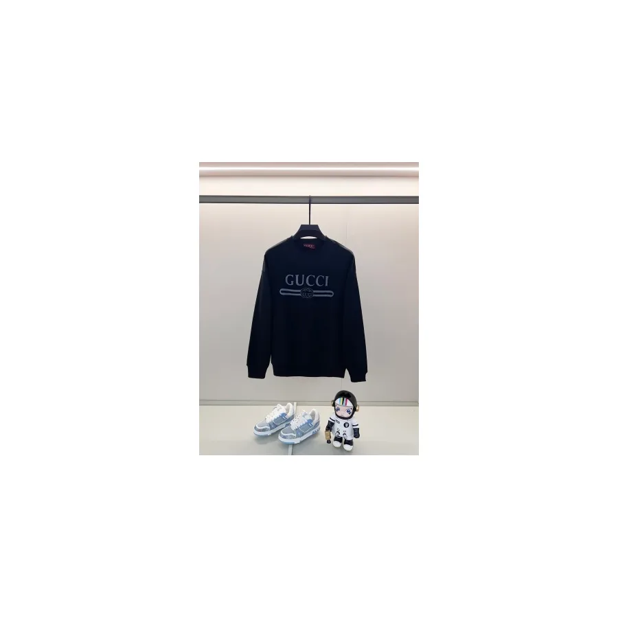 Navy Gucci crewneck sweatshirt on a hanger with a white Gucci logo print across the chest