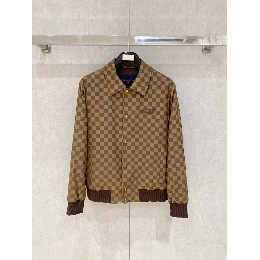 Brown check jacket with a snap placket and ribbed hem, showing a blue lining and label
