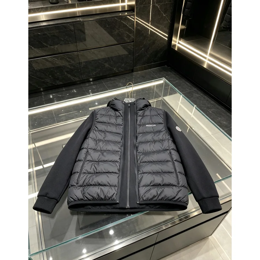 Black Moncler hooded down jacket with a glossy quilted front panel and matte knit sleeves