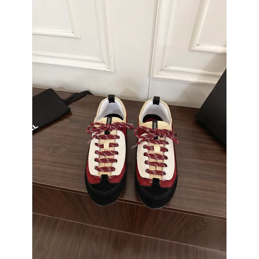 Cream and deep burgundy suede Chanel sneaker with a cream mesh base, burgundy suede overlays on the toe cap and heel, a black heel tab and a medium-thick black rubber platform sole