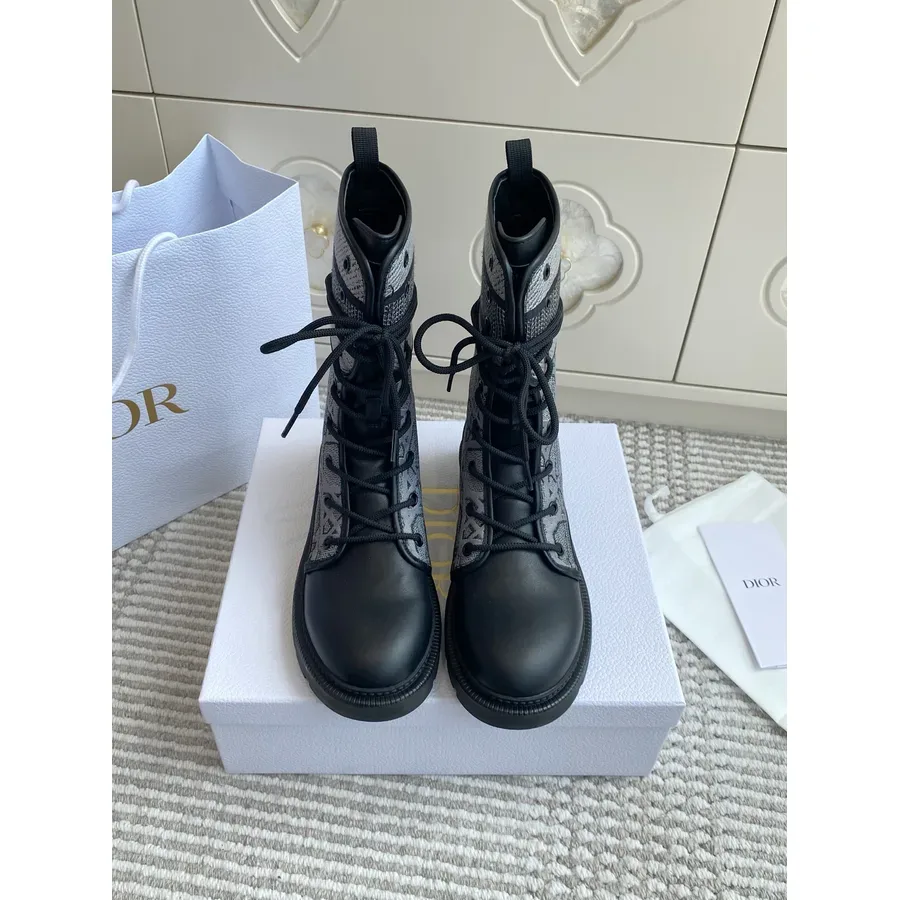 Black canvas Dior boot photographed from the front, lace panel and sole visible