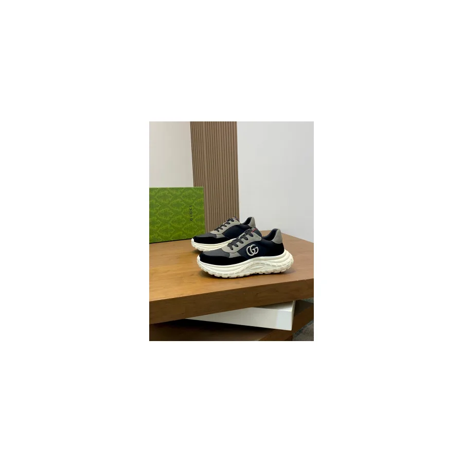 Gucci chunky sneaker in black and grey leather on a thick white sole, shown from a three-quarter angle with the interlocking G logo visible on the side panel
