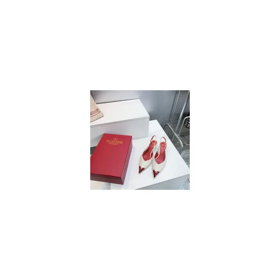 White pointed-toe slingback pump with a red tip and a red heel under a thin ankle slingback strap